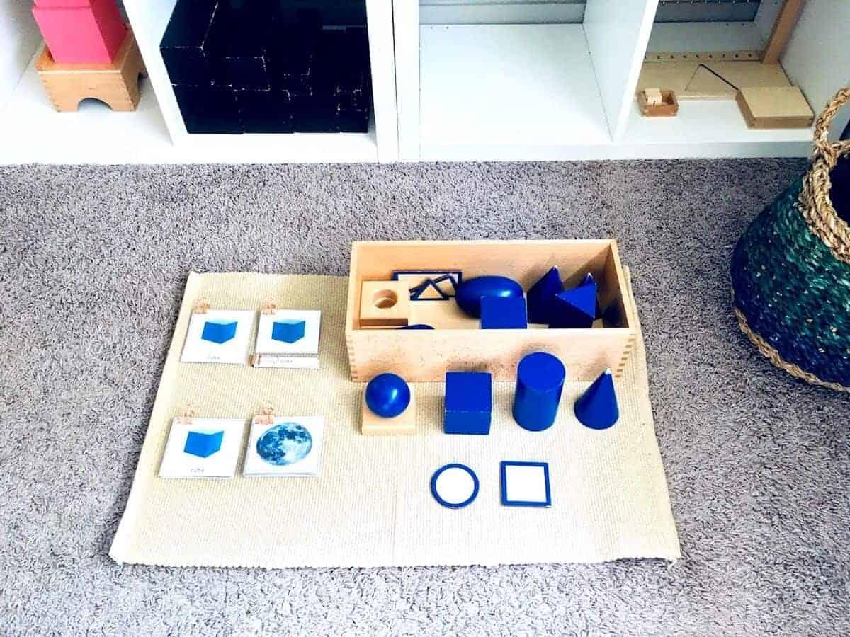 Montessori Geometric Solids, nomenclature cards, and sorting extension on a work mat in homeschool