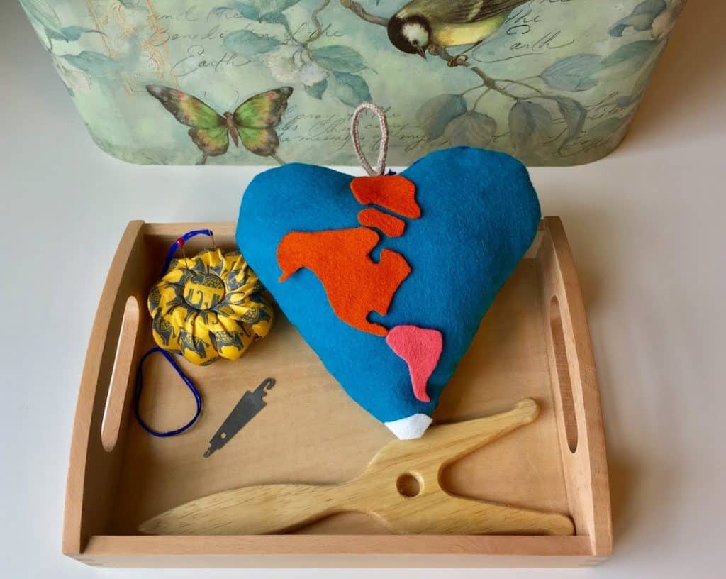hanging heart pillow on a montessori tray