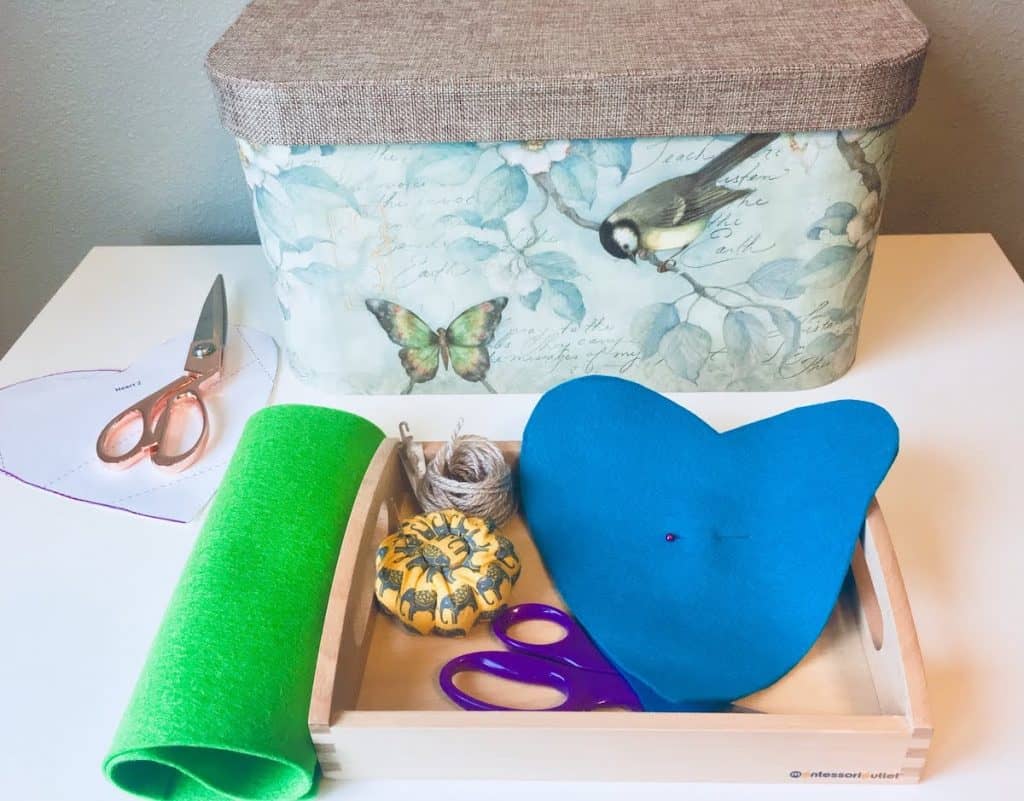 montessori tray with felt, scissors, a pincushion, and thread
