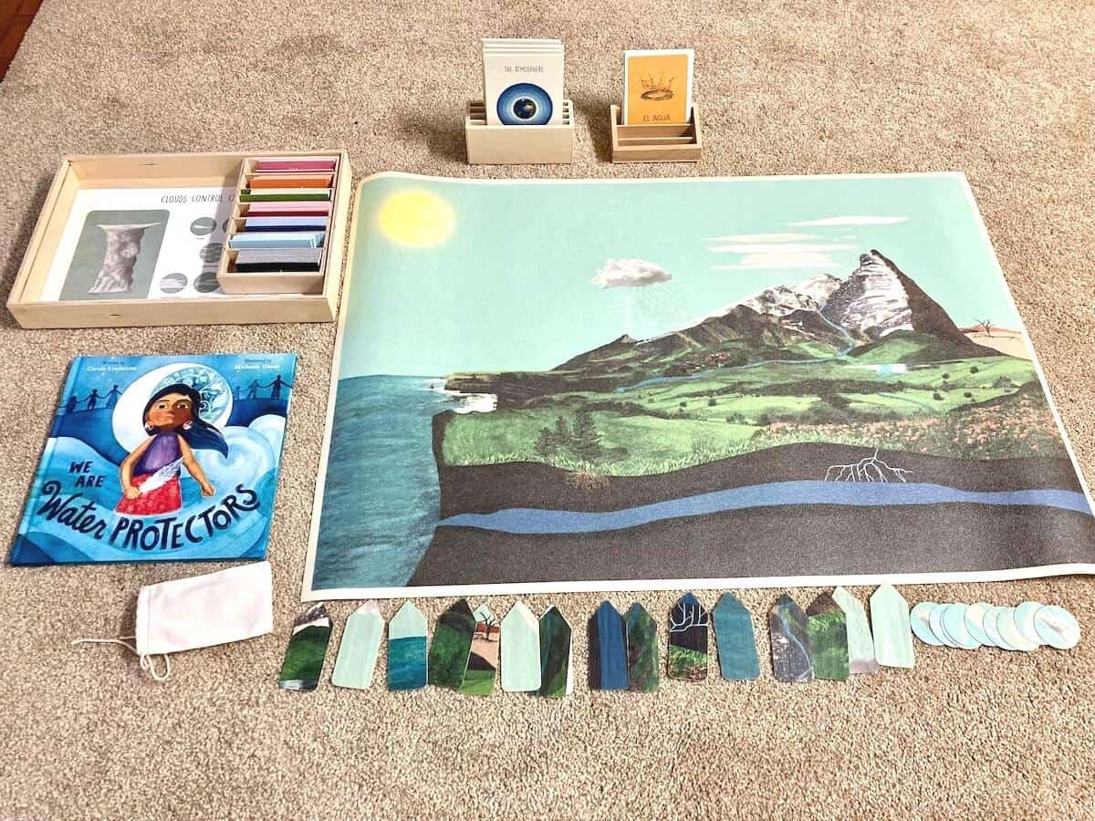 water cycle mat and materials on the floor with We Are Water Protectors book for Earth Science activities
