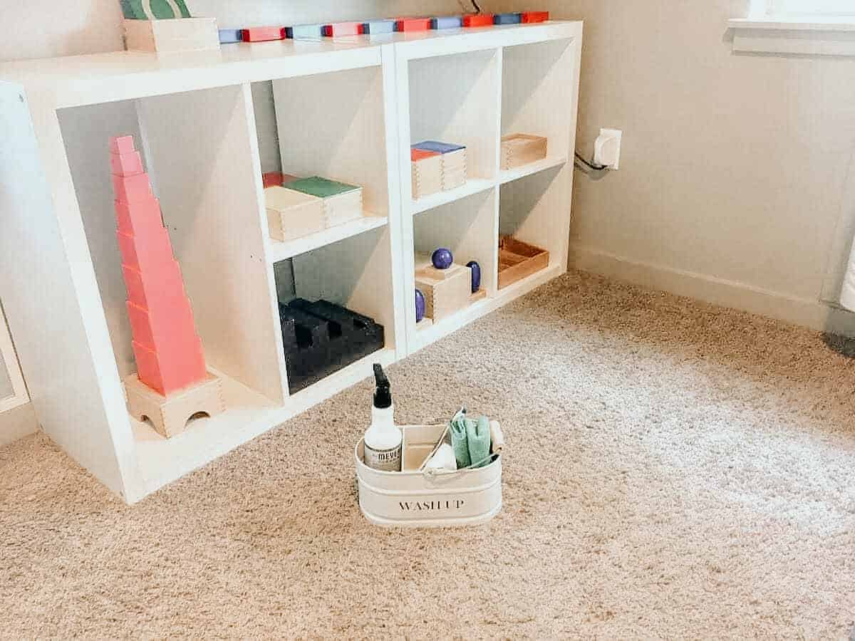 cleaning supplies in front of Montessori homeschool shelves for practical life work