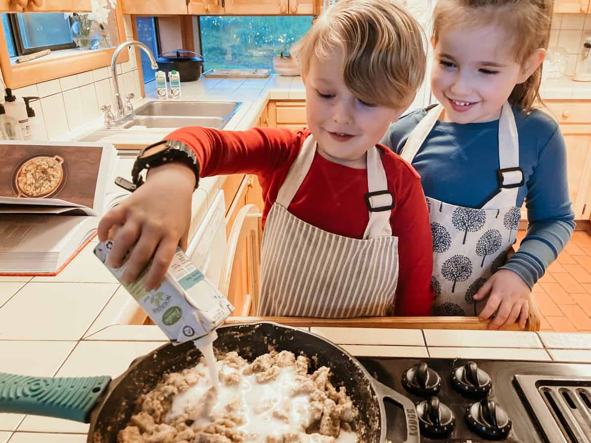 Kids adding coconut milk to South American Food 