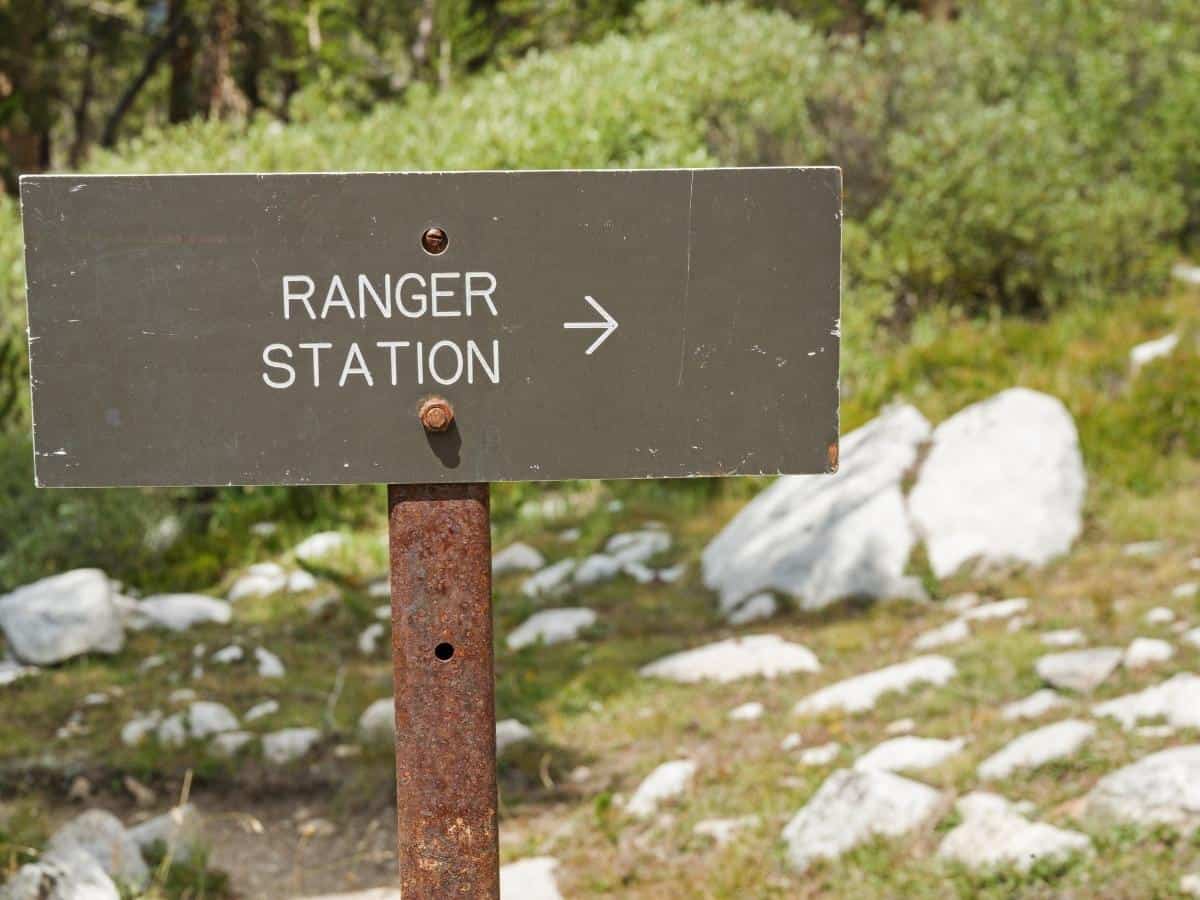 sign for a ranger station with an arrow pointing right