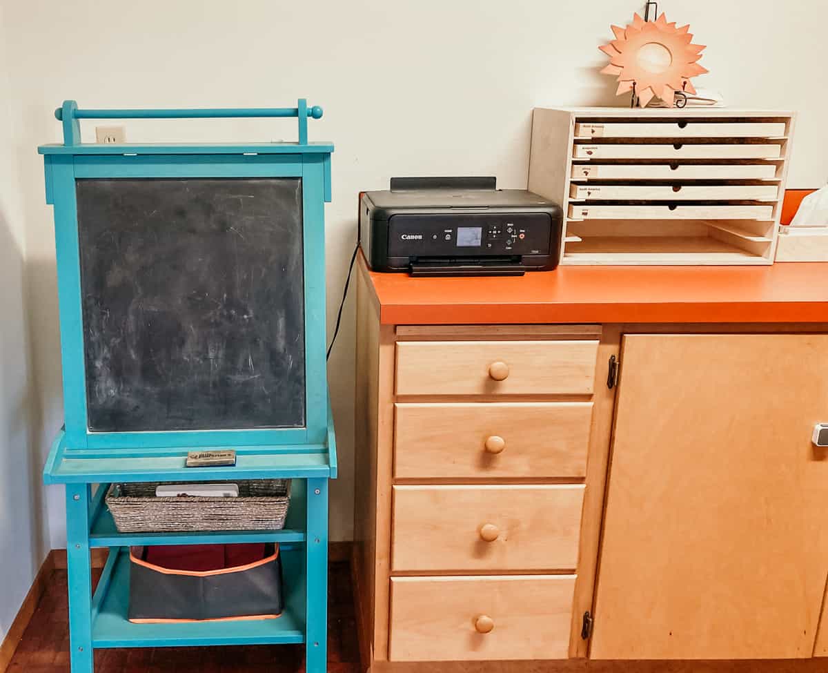 easel, printer and cabinets for storing homeschool work