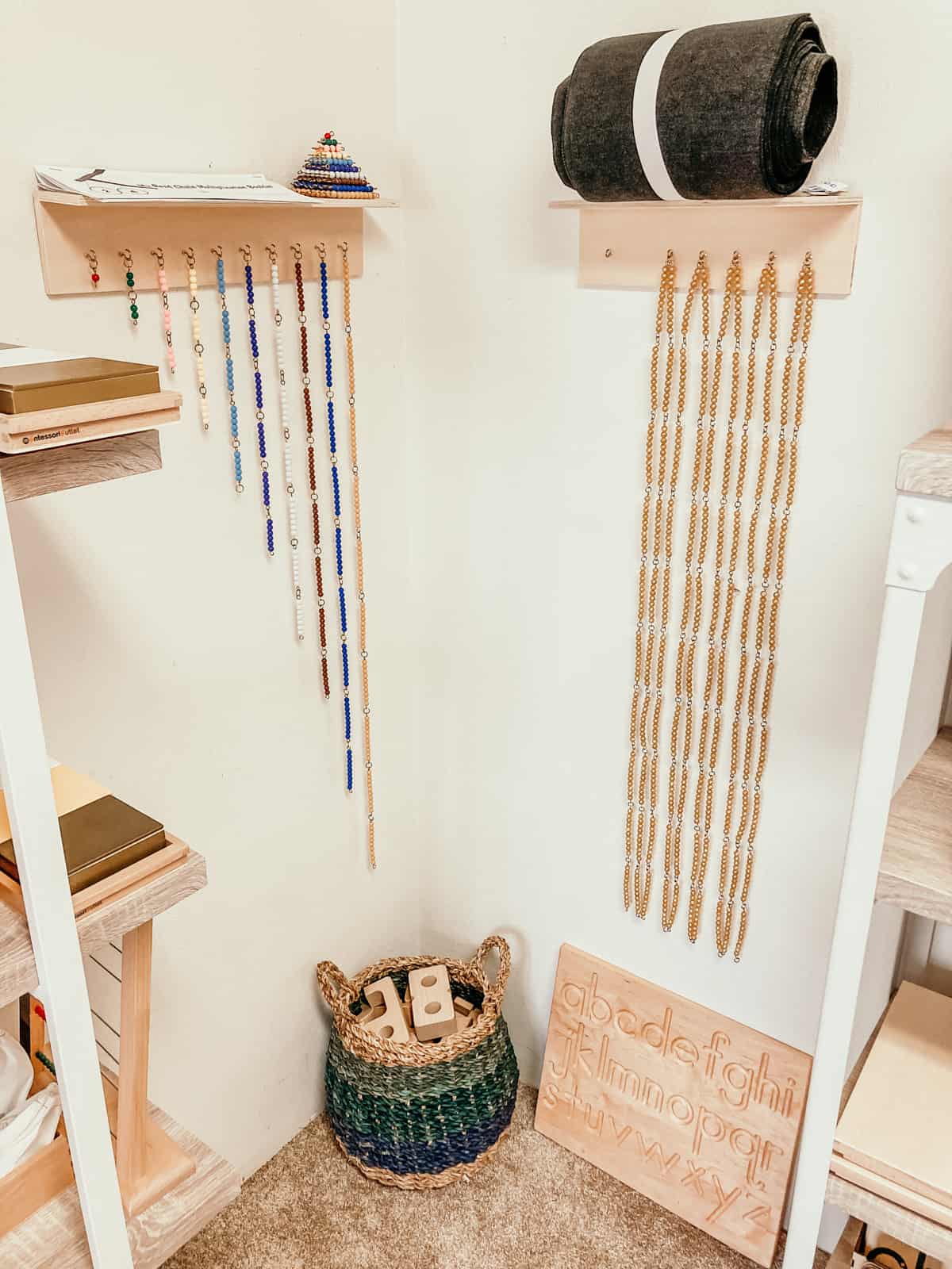 Montessori short bead chains and thousand bead chain hanging on the wall with a basket of sumblox beneath