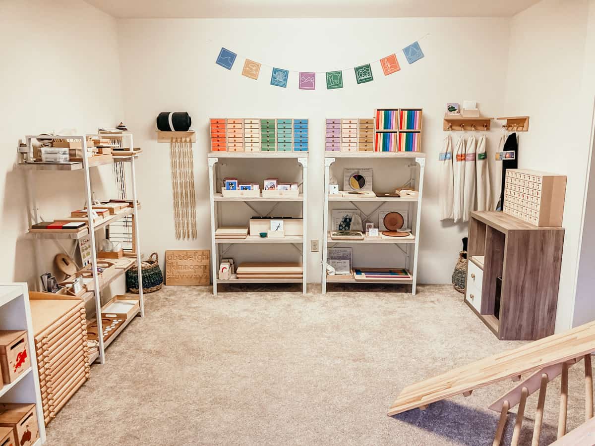 Montessori homeschool room, including reading, language, and grammar materials on shelves and in drawers
