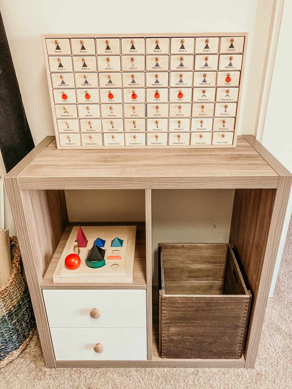 grammar materials in a cabinet sitting on a shelf of a Montessori homeschool room
