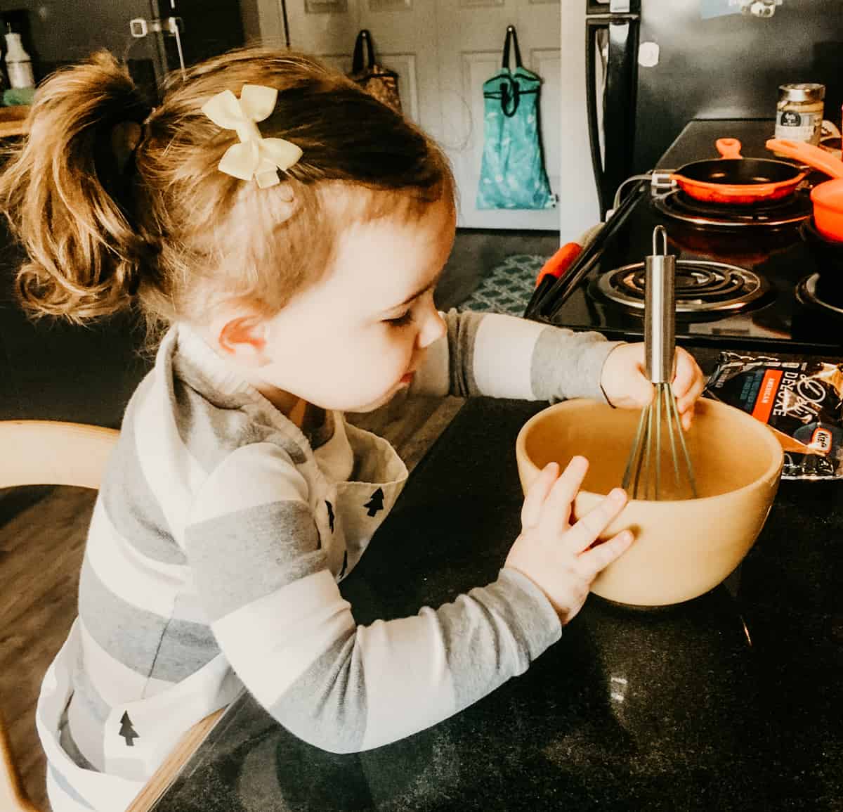a child whisking eggs in a bowl 