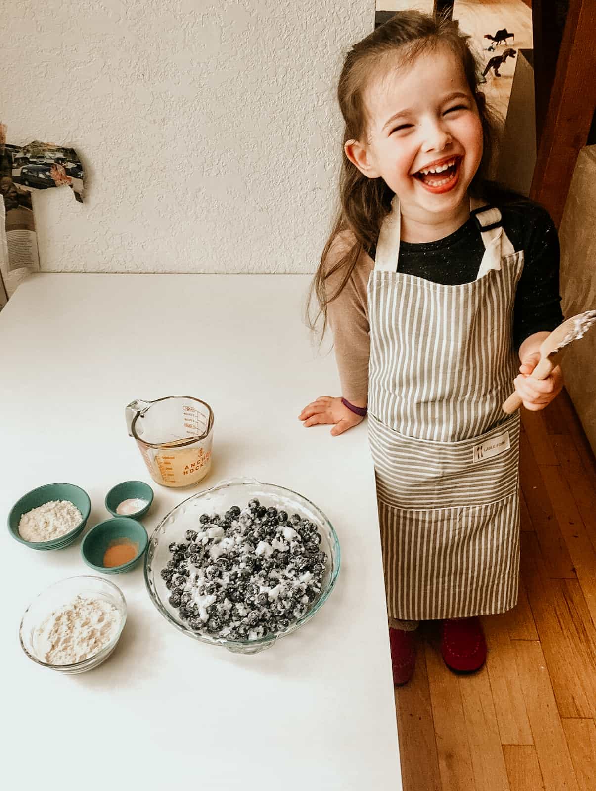 Montessori child enjoying the taste of the easy blueberry cake mixture.