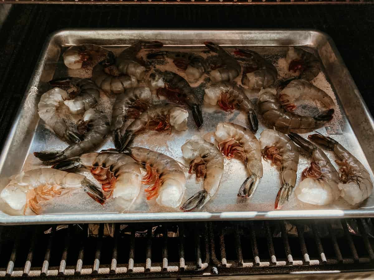 a tray of uncooked prawns on a grill