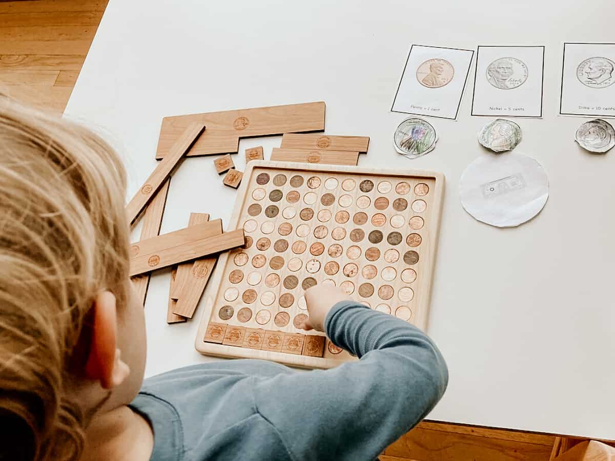 a child working with the Mirus Toys dollar counting board alongside some printable coins.  Resources for the best preschool and kindergarten homeschool curriculum 