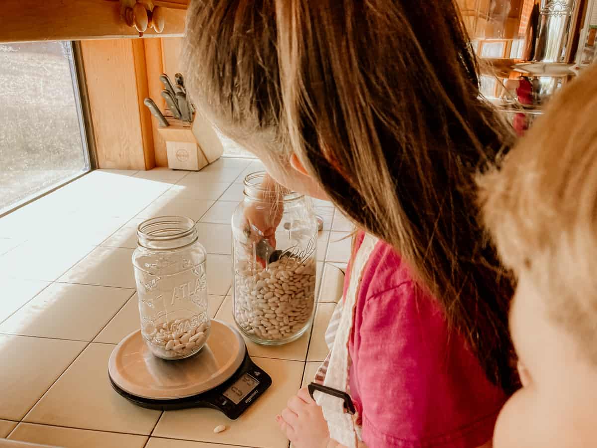 child weighing cannellini beans on a kitchen scale