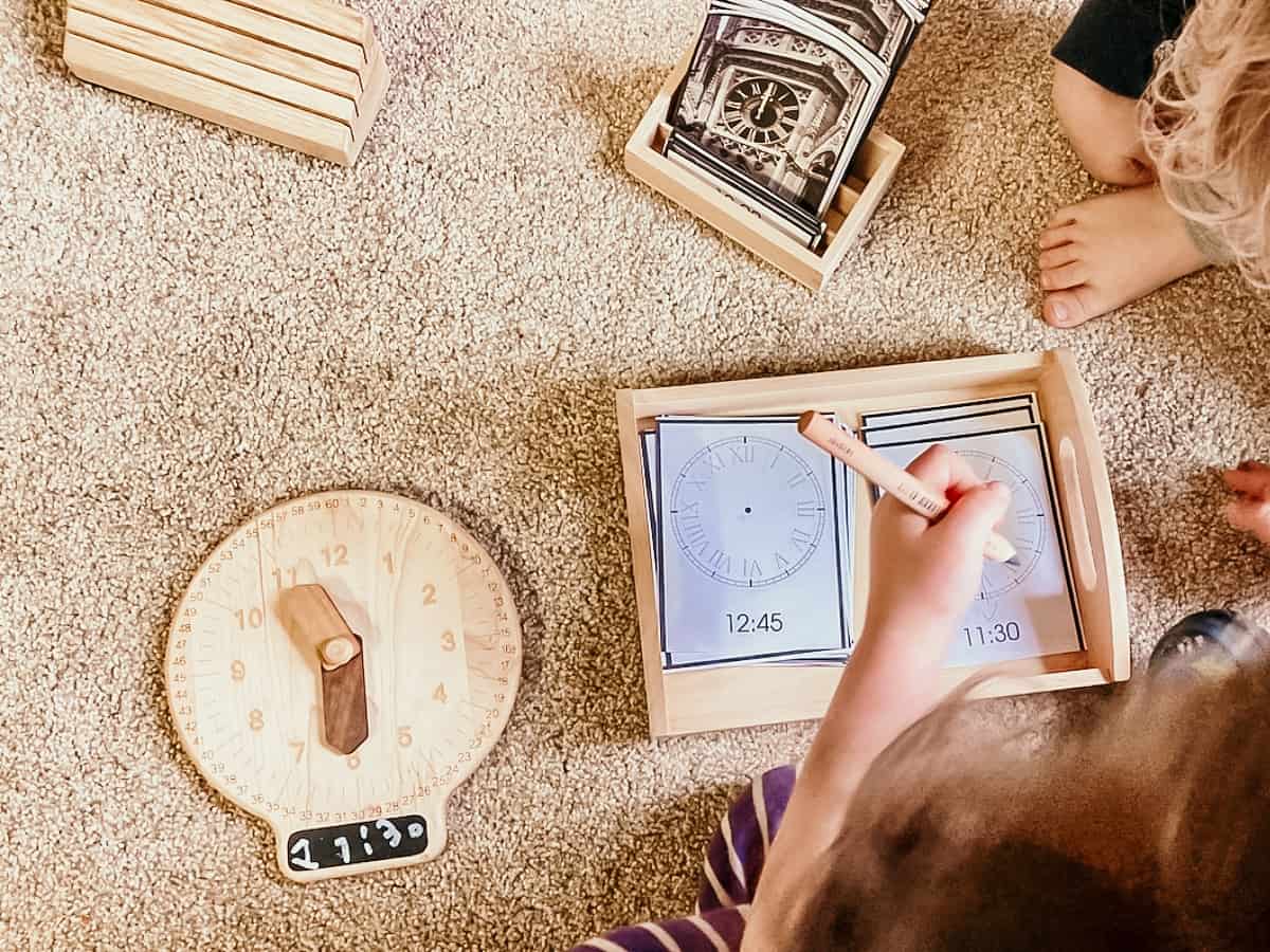 child drawing hands on a roman numeral clock face card