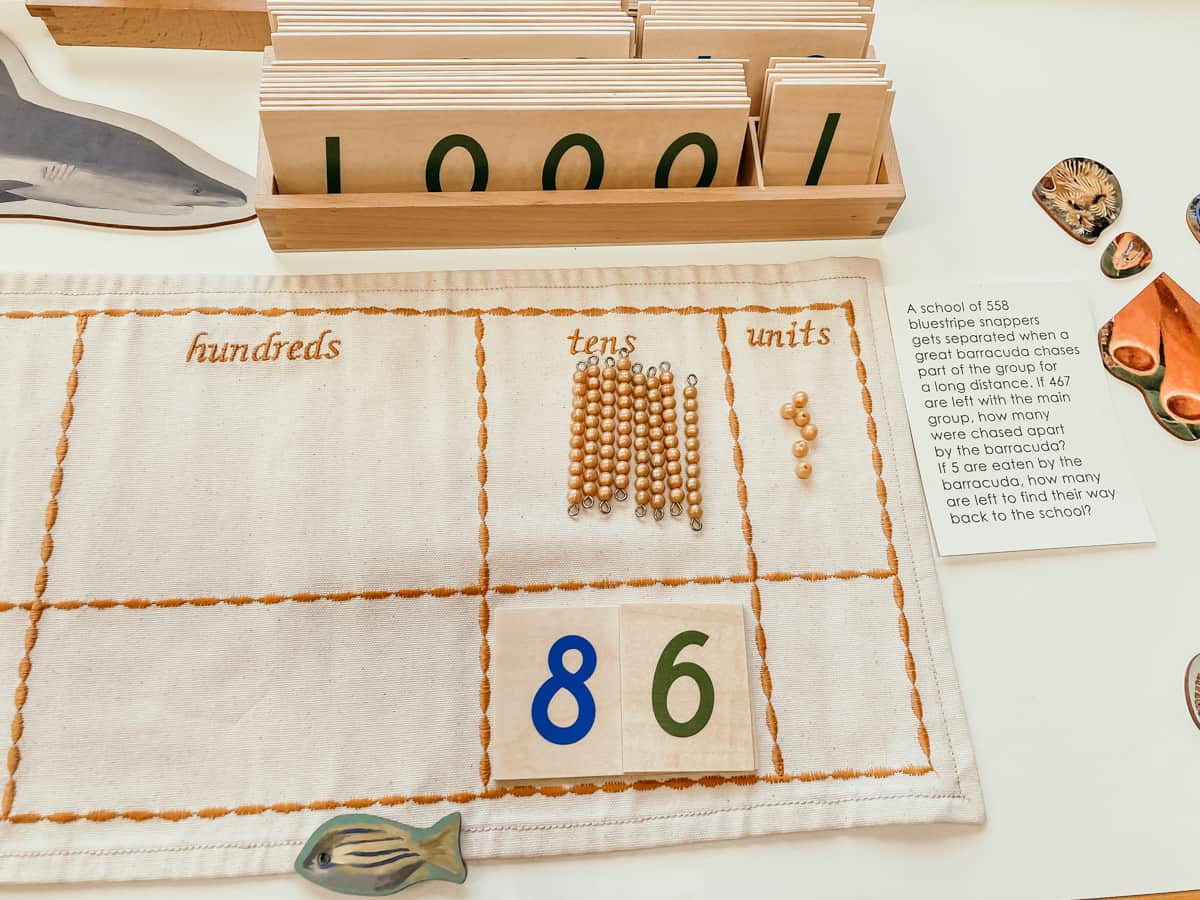 Montessori Golden Bead materials on a place value mat next to a word problem card from the Waseca Biomes Coral Reef Habitat Mat.
