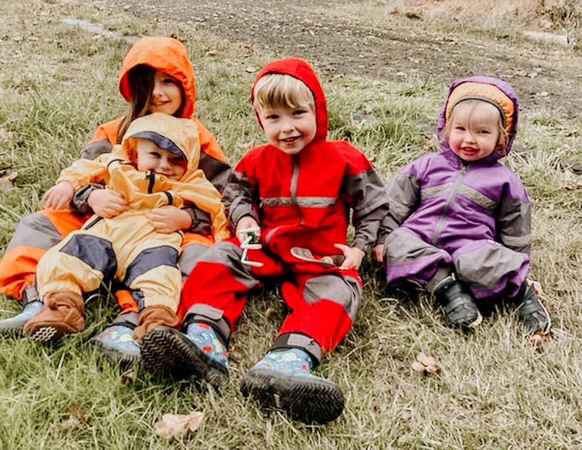 picture of children in trailsuits sitting on the grass