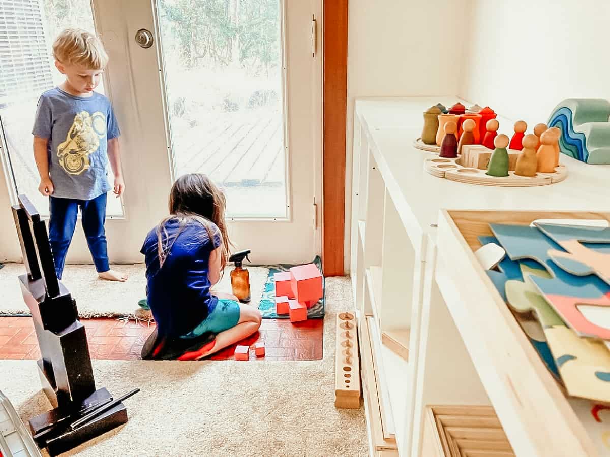 kids cleaning their homeschool room with spray bottles and washcloths