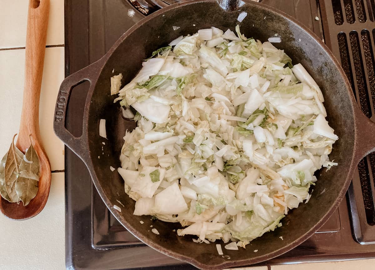 chopped cabbage and onions cooking in a pan