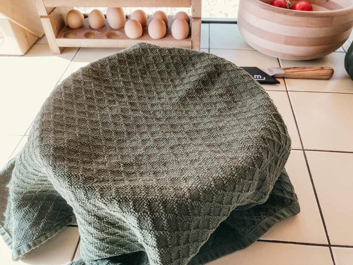 a bowl with a kitchen towel resting on top