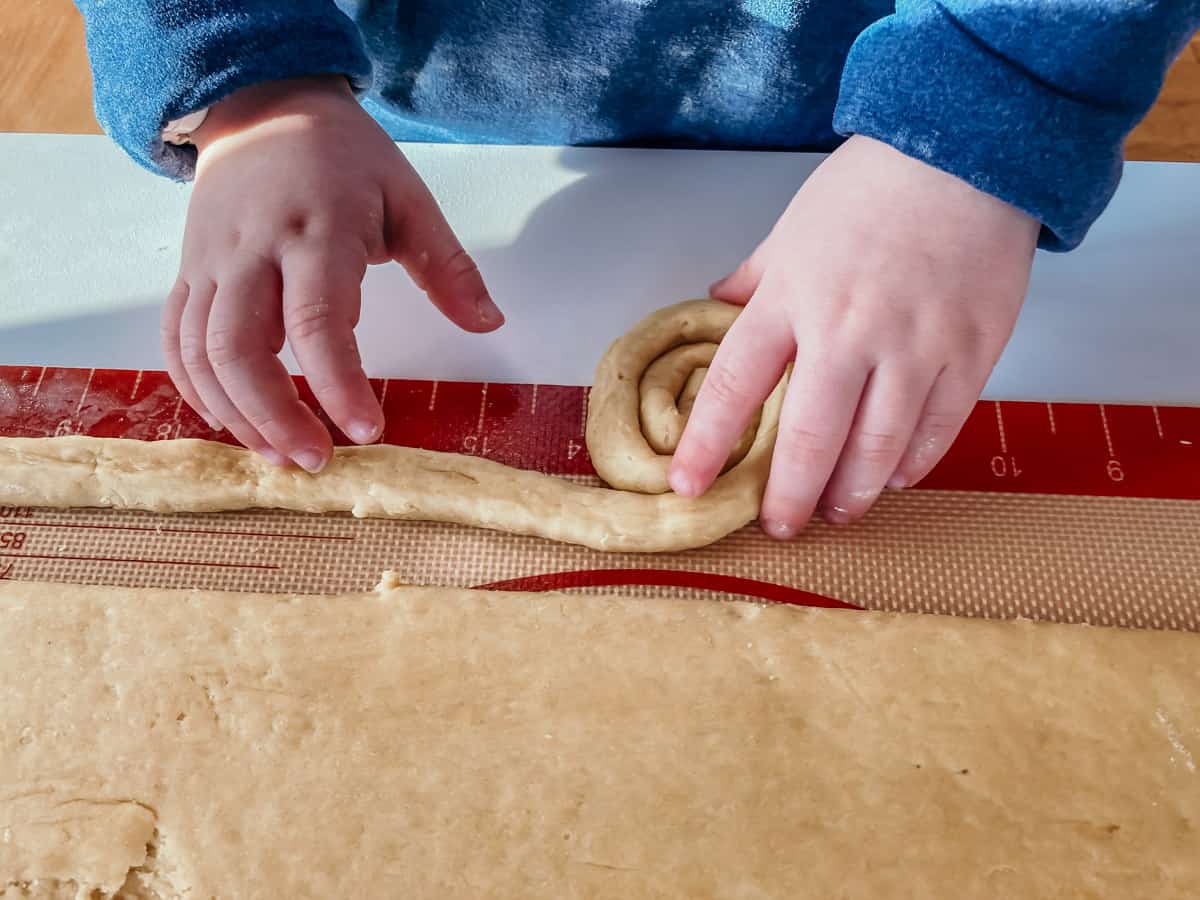 child rolling dough for mallorcas