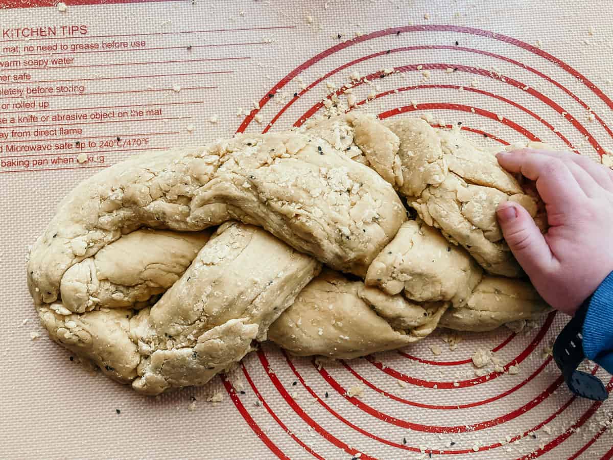 braided dough for making easter bread on a silicone baking mat