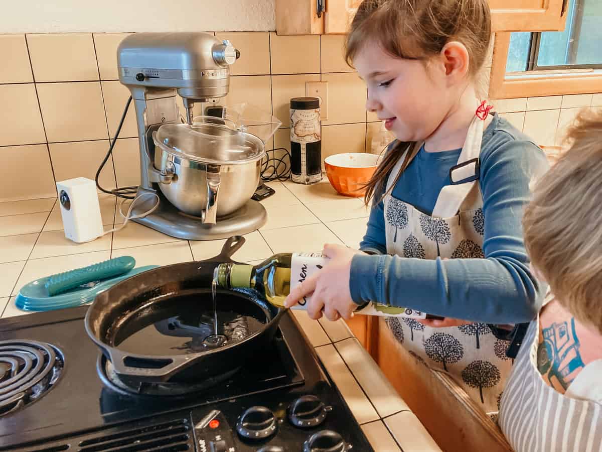 homeschool child adding avocado oil to a pan for making shumai dumpling