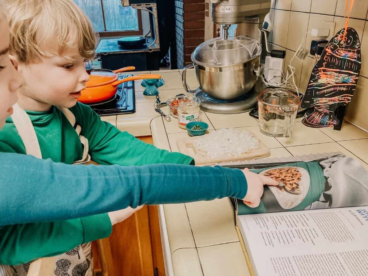 kids pointing to jollof rice recipe picture in black food cookbook