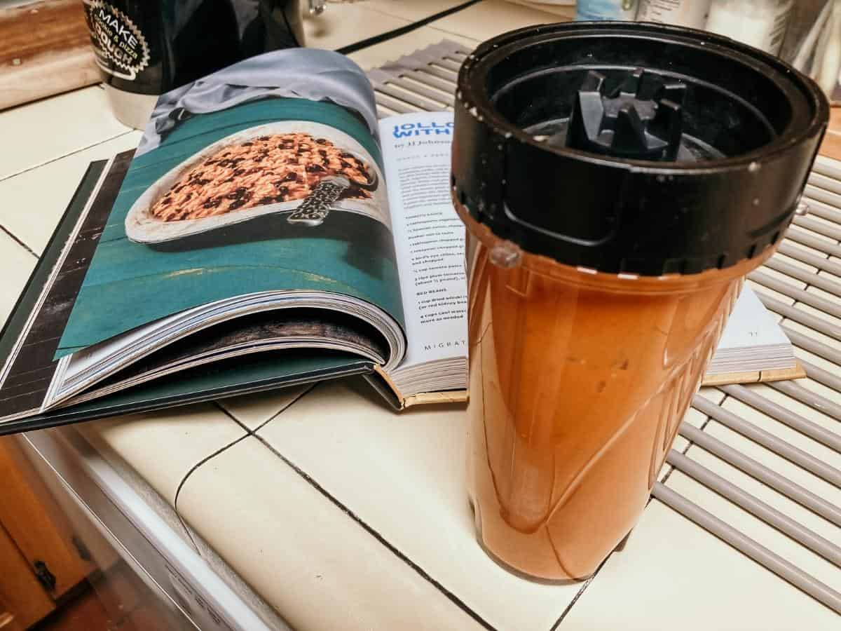 blender cup next to a cookbook about african cuisine