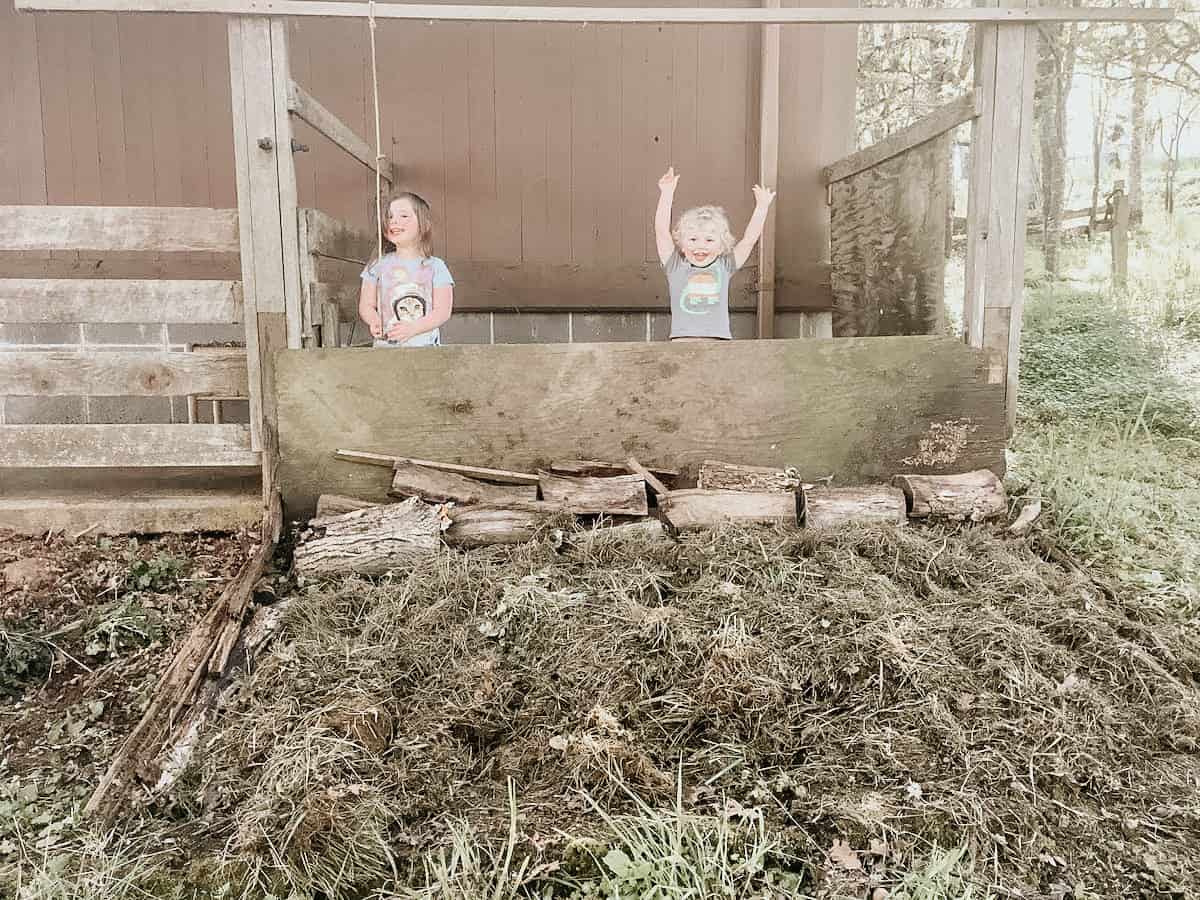 kids standing over a composting site