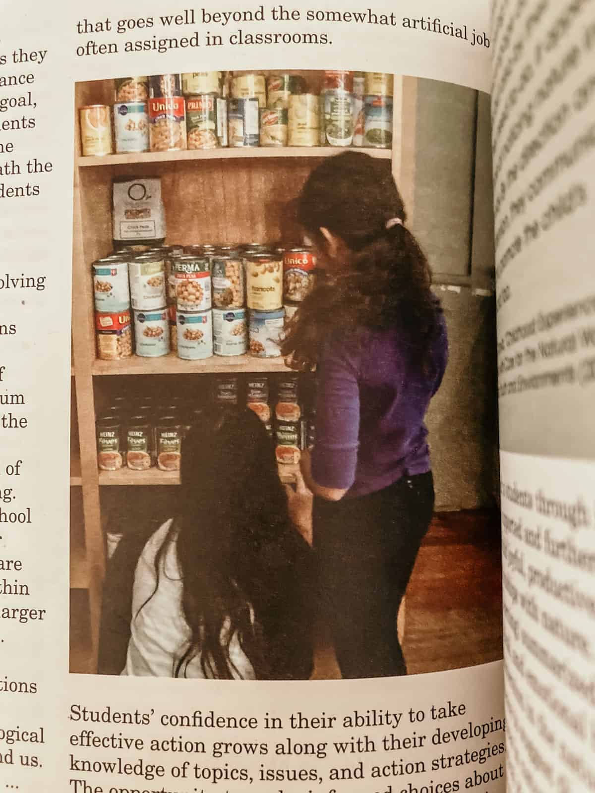 child and adult examining the contents of a pantry and the canned goods inside