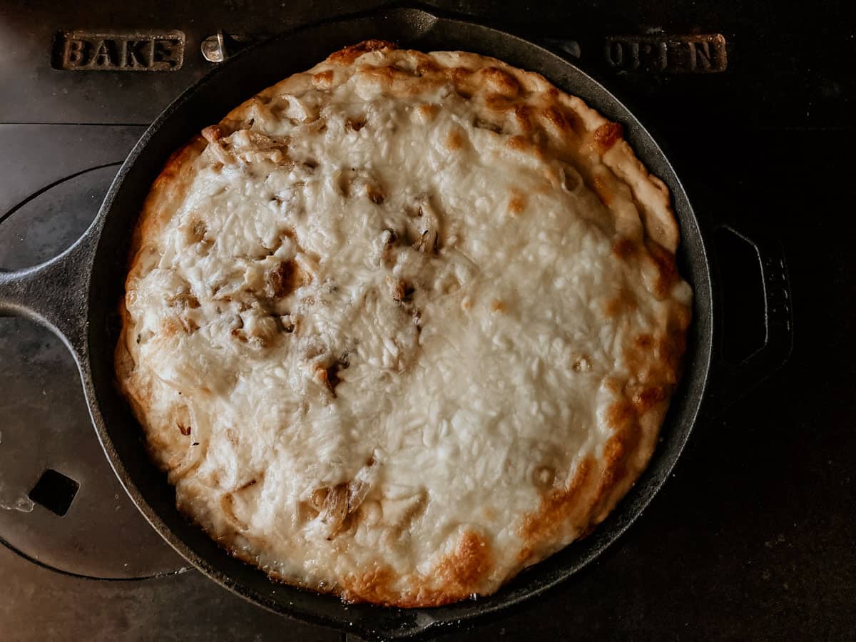 Argentine stuffed crust pizza in a Lodge cast iron pan on the stove