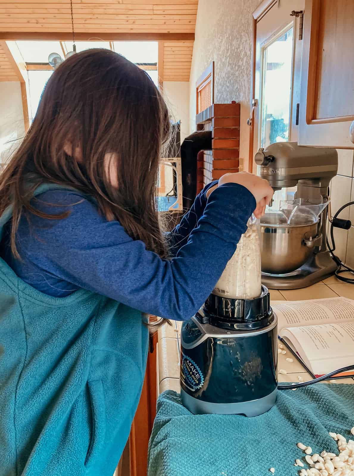 a child is blending black-eyed peas and water in the kitchen