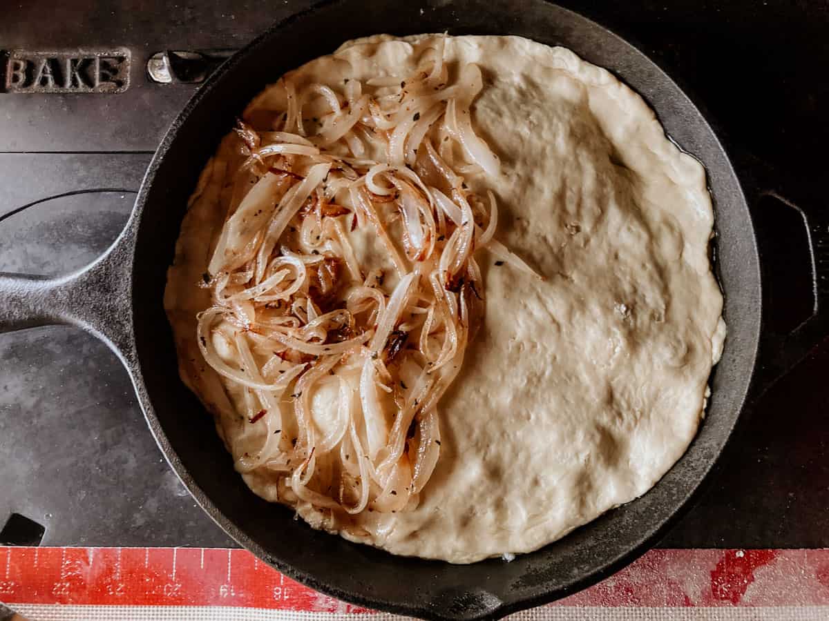 top of a stuffed crust pizza, half covered with onions