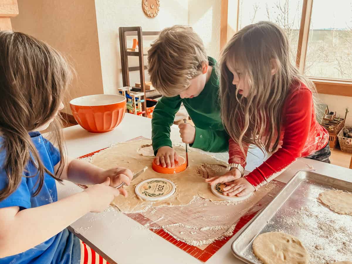 kids at a table cutting circles out of empanadilla dough