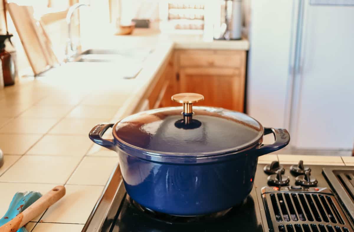Made In 5.5 quart Harbour Blue Dutch oven with Antique Brass Knob sitting on a stovetop