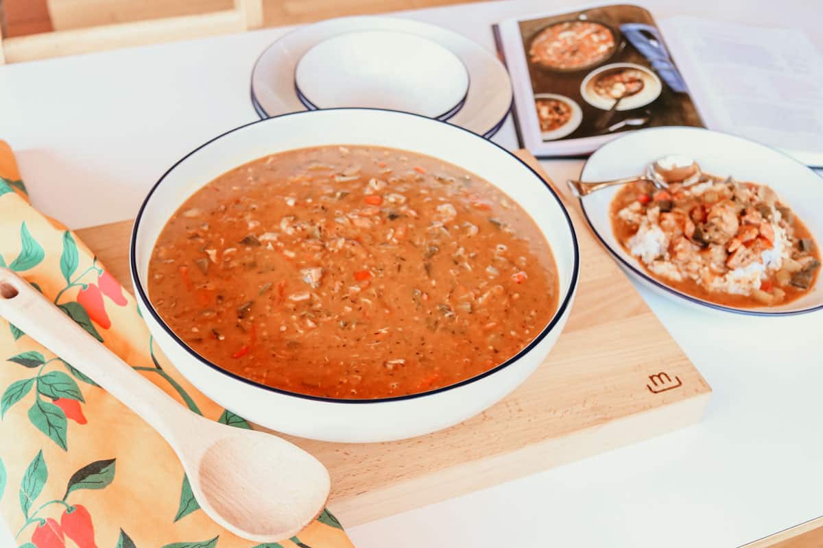 Afro-Asian-American gumbo in a large serving bowl and entrée bowl next to an image of gumbo from Between Harlem and Heaven cookbook