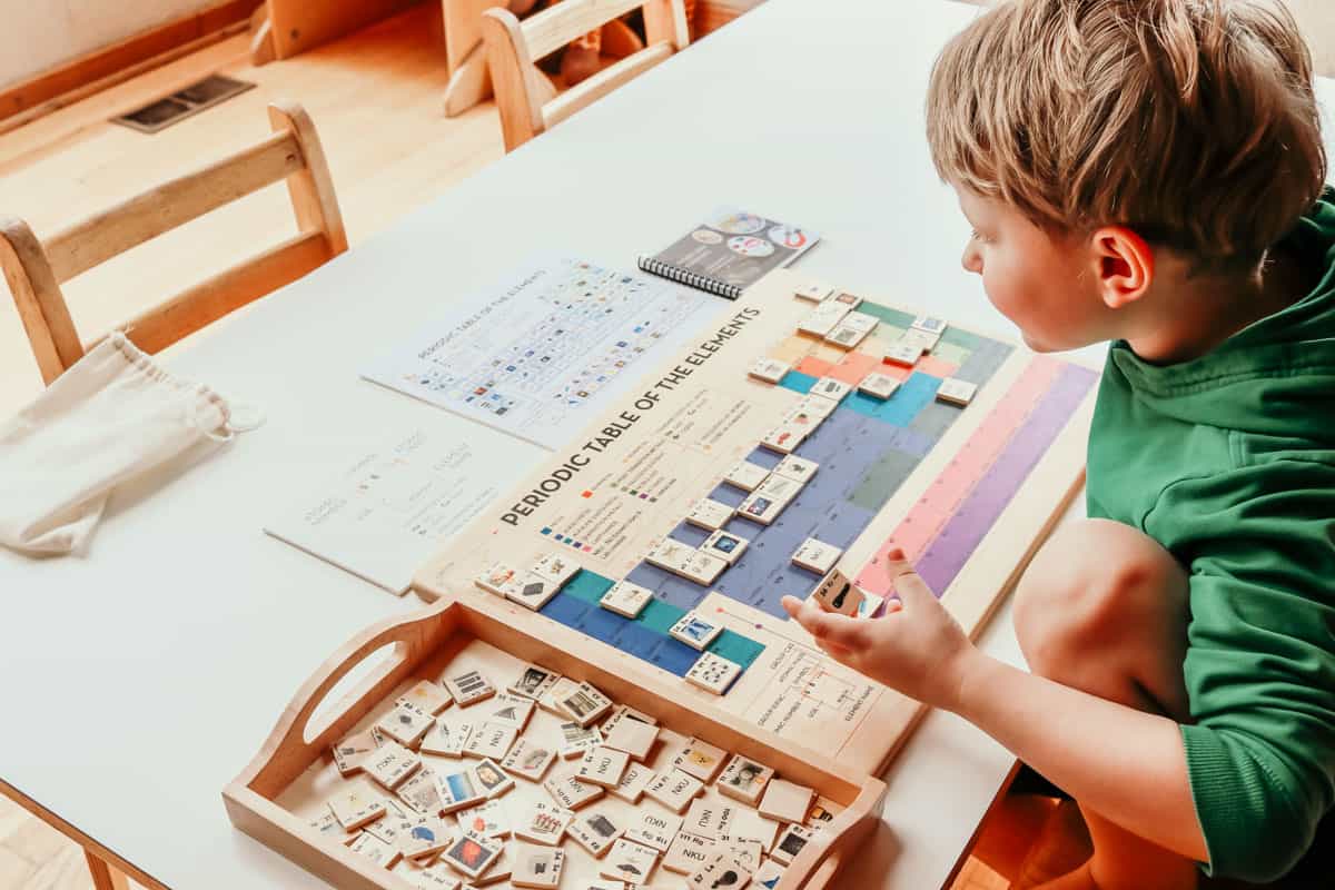 child working with the Mirus Toys Periodic Table of the Elements Puzzle for exploring the history of the universe.