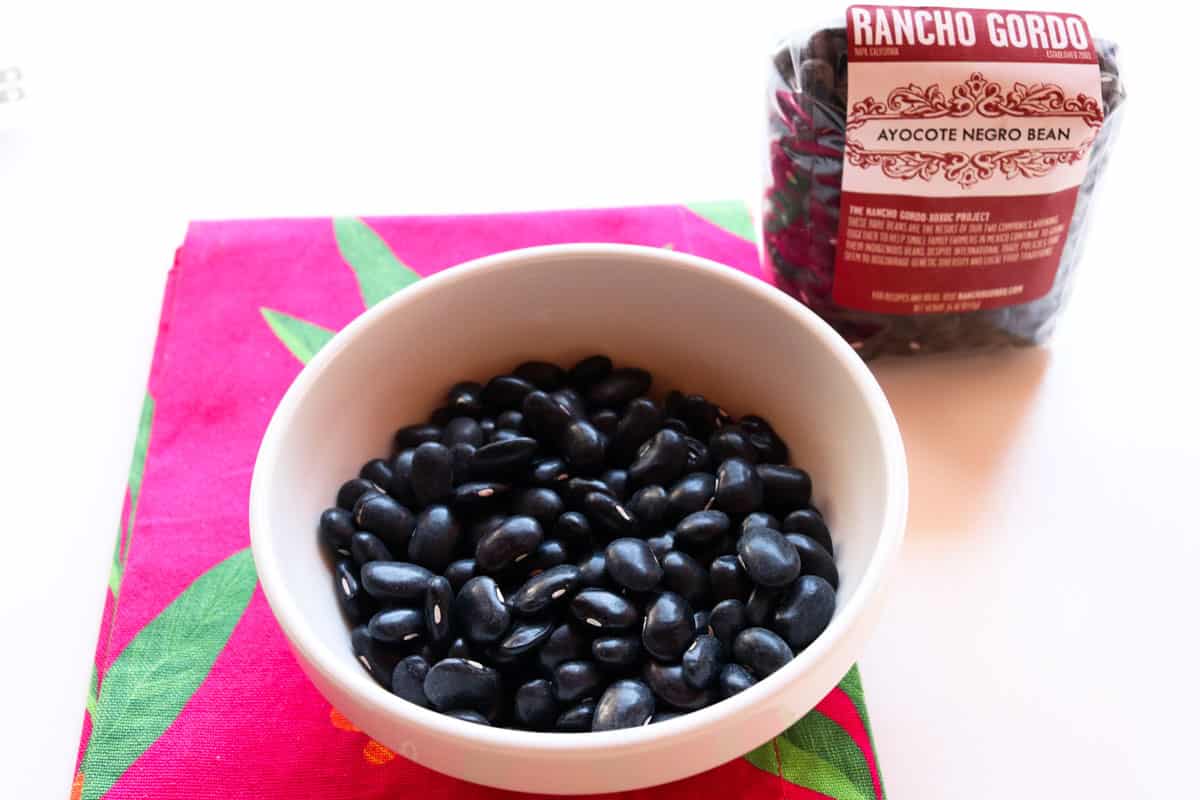 Ayocote Negro beans in a bowl and in the packaging