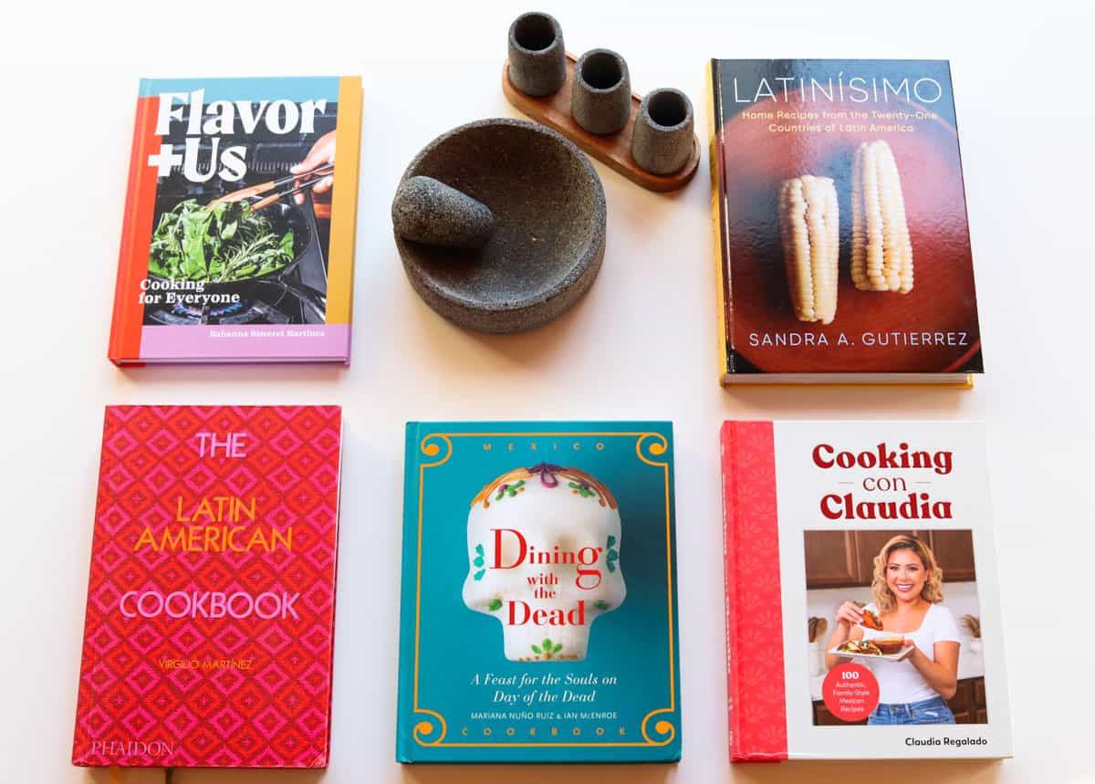 cookbooks with Mexican and/or Latin American recipes and a molcajete with tequileros