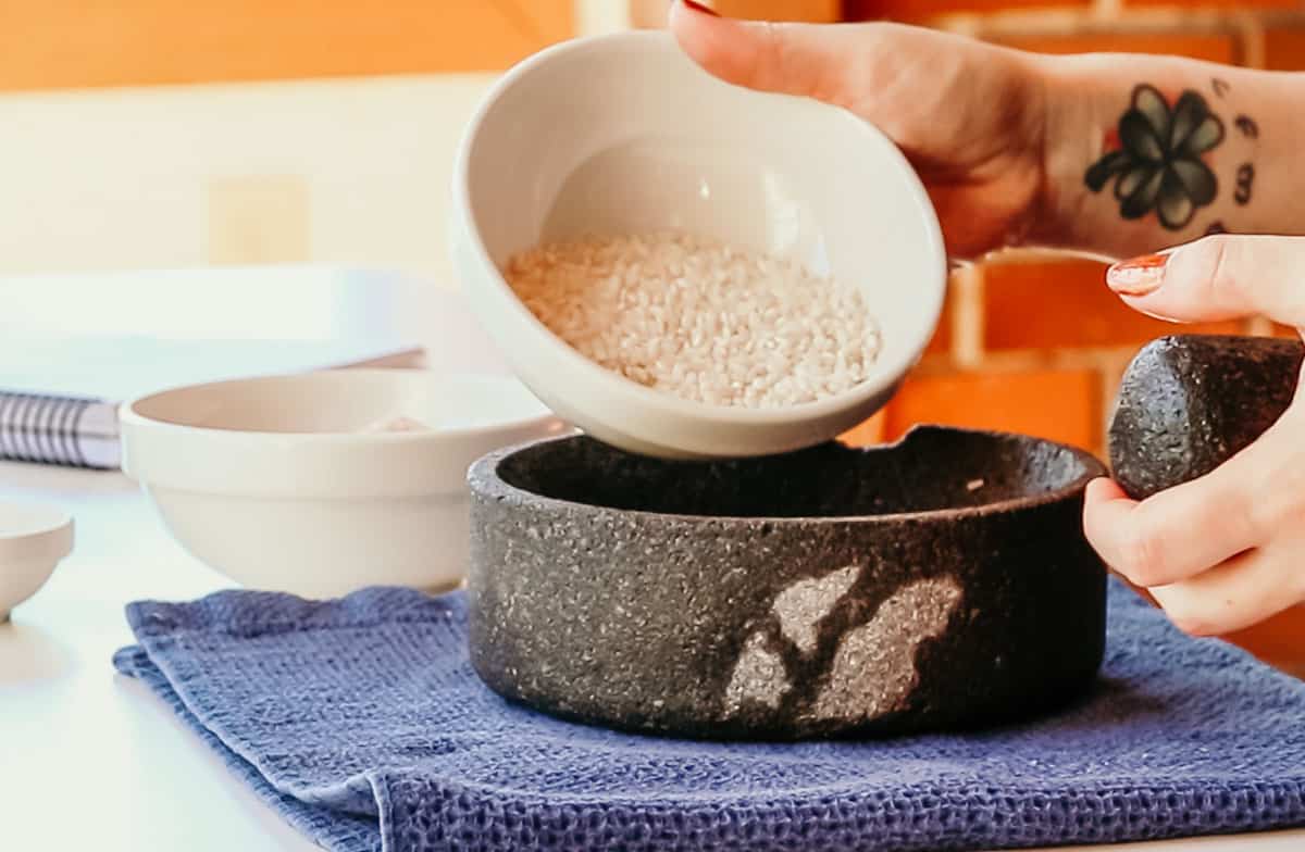 pouring rice into a Made In molcajete to cure it