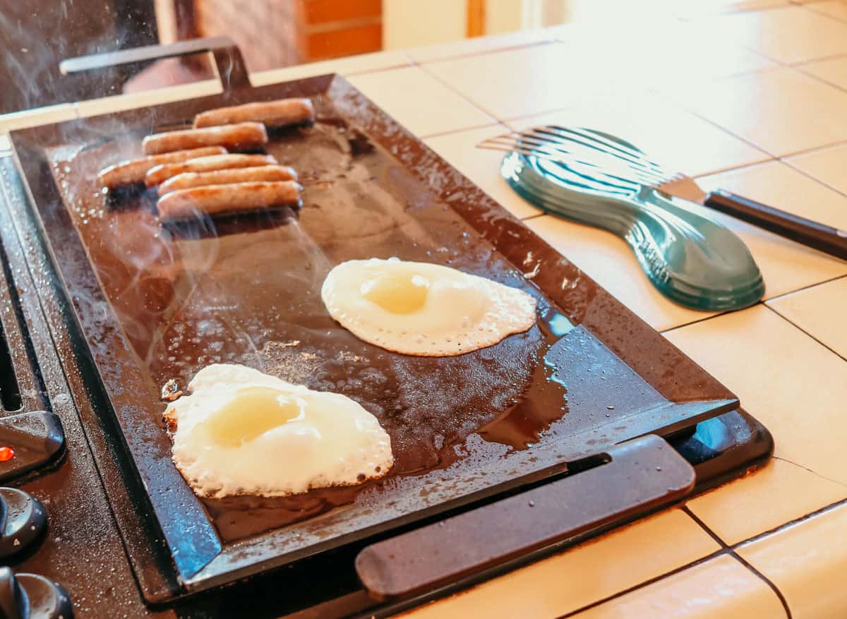 sunny-side-up eggs and sausage cooking on a Made In griddle