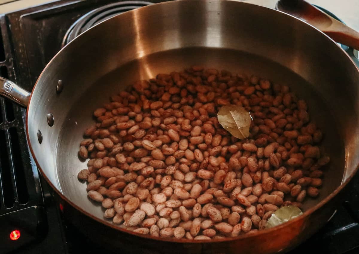 pinto beans and bay leaves in a saucier