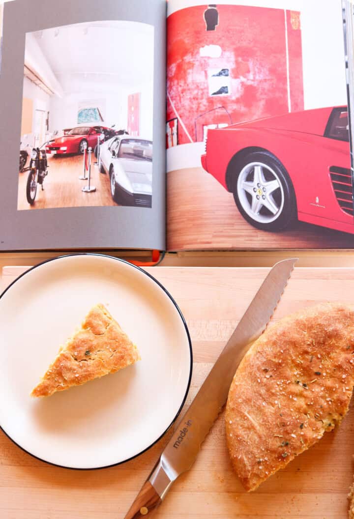 focaccia on a plate and butcher block beside slow food, fast cars book