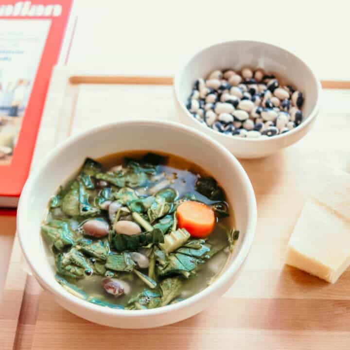 calypso beans and greens in a bowl beside a bowl of orca beans and cheese