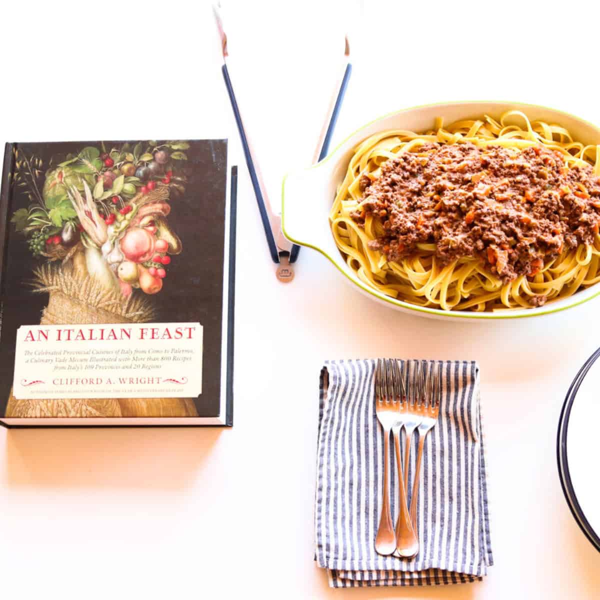 bison bolognese in a baking dish beside An Italian Feast cookbook