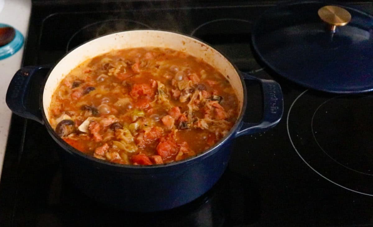 bigos ingredients cooking in a Dutch oven