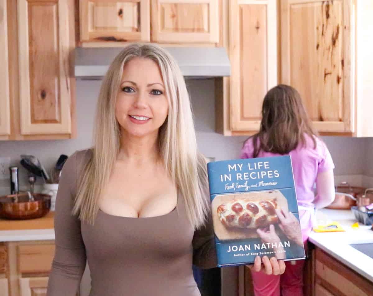 Krisitn is holding My Life in Recipes and Kaia is chopping prunes