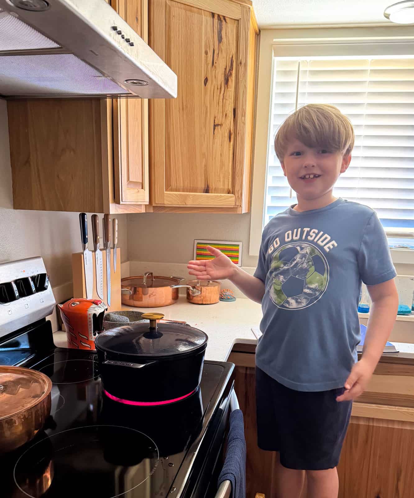 Noah is on a chair to check on the bigos brisket