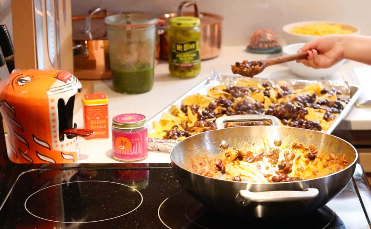 Katalina is spooning rajma over the tortilla chips