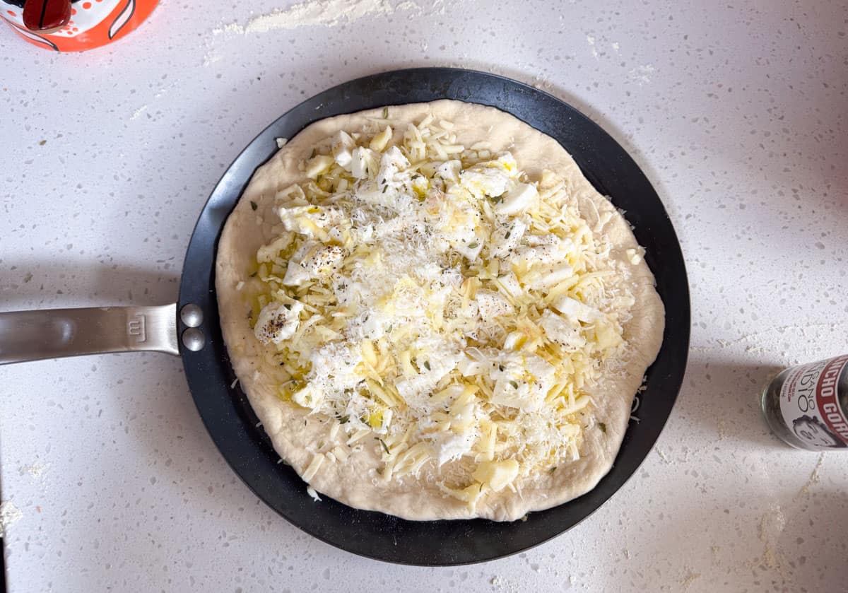 uncooked white pie on a made in carbon steel tawa