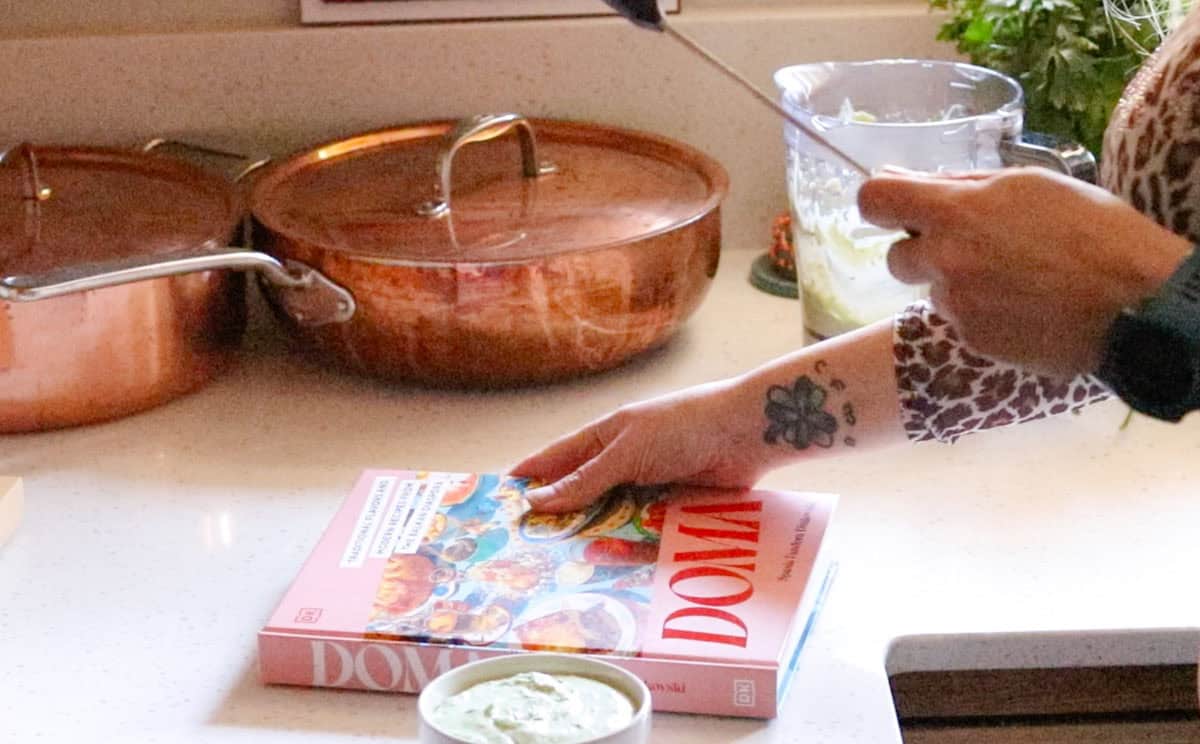 Doma cookbook beside feta sauce